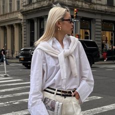 A woman wearing a cream outfit with creamy, bright blonde hair