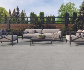 Mineral Grey Rustic Edge Stone Effect Porcelain Outdoor Slab on a patio with outdoor furniture