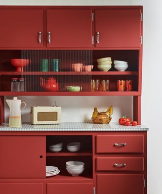 kitchen cabinets painted dark red with decorative objects on display