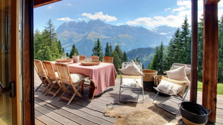 A garden table and chairs on the terrace of a ski chalet overlooking the Dents du Midi