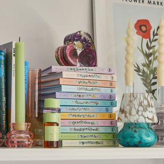 Stack of books, candles, decorative items on shelf