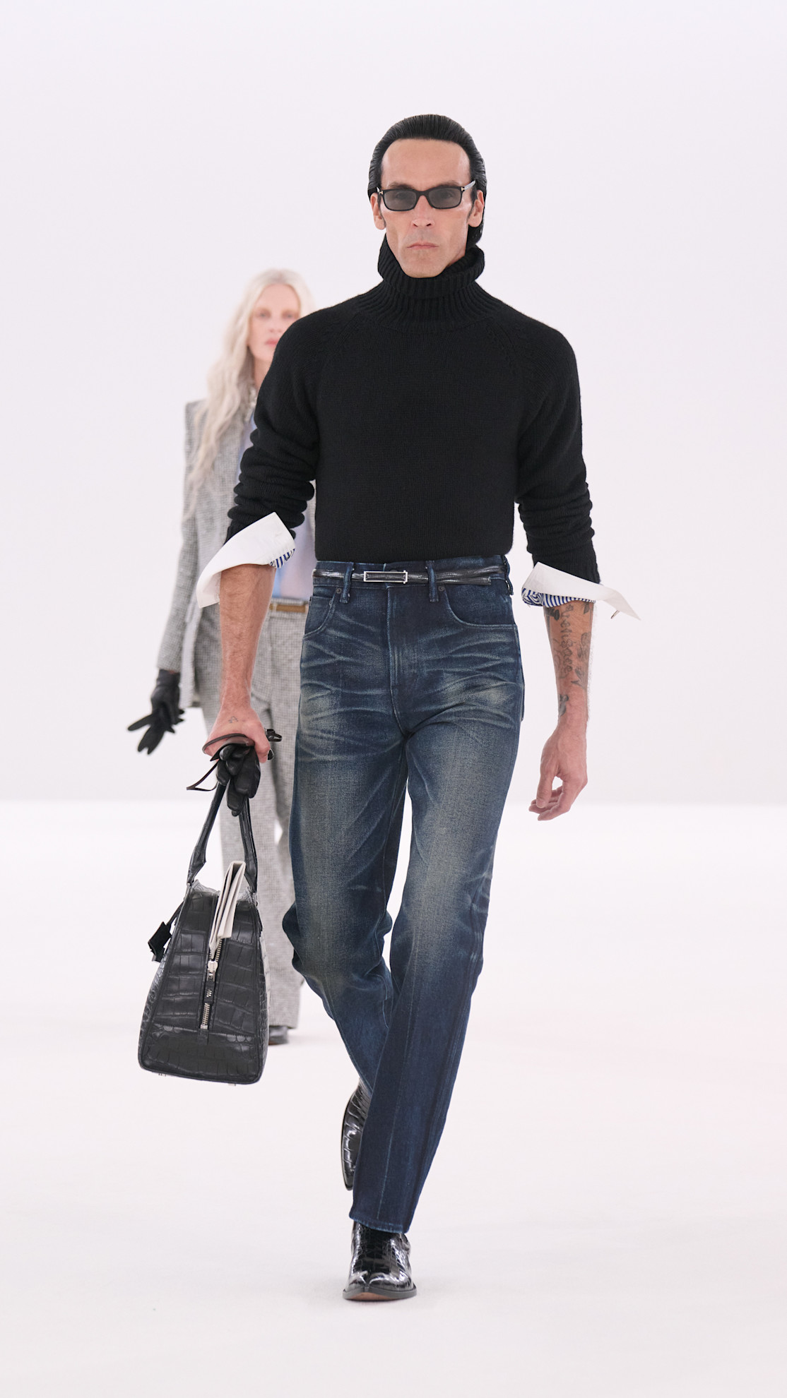 a Tom Ford model wearing a black turtleneck, and denim jeans