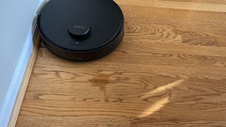 Yeedi C12 Pro Plus robot vacuum approaching a puddle of fare Coke connected a difficult floor