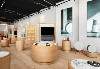 Bang & Olufsen speakers and headphones sit on wooden shelves the flagship shop in NYC