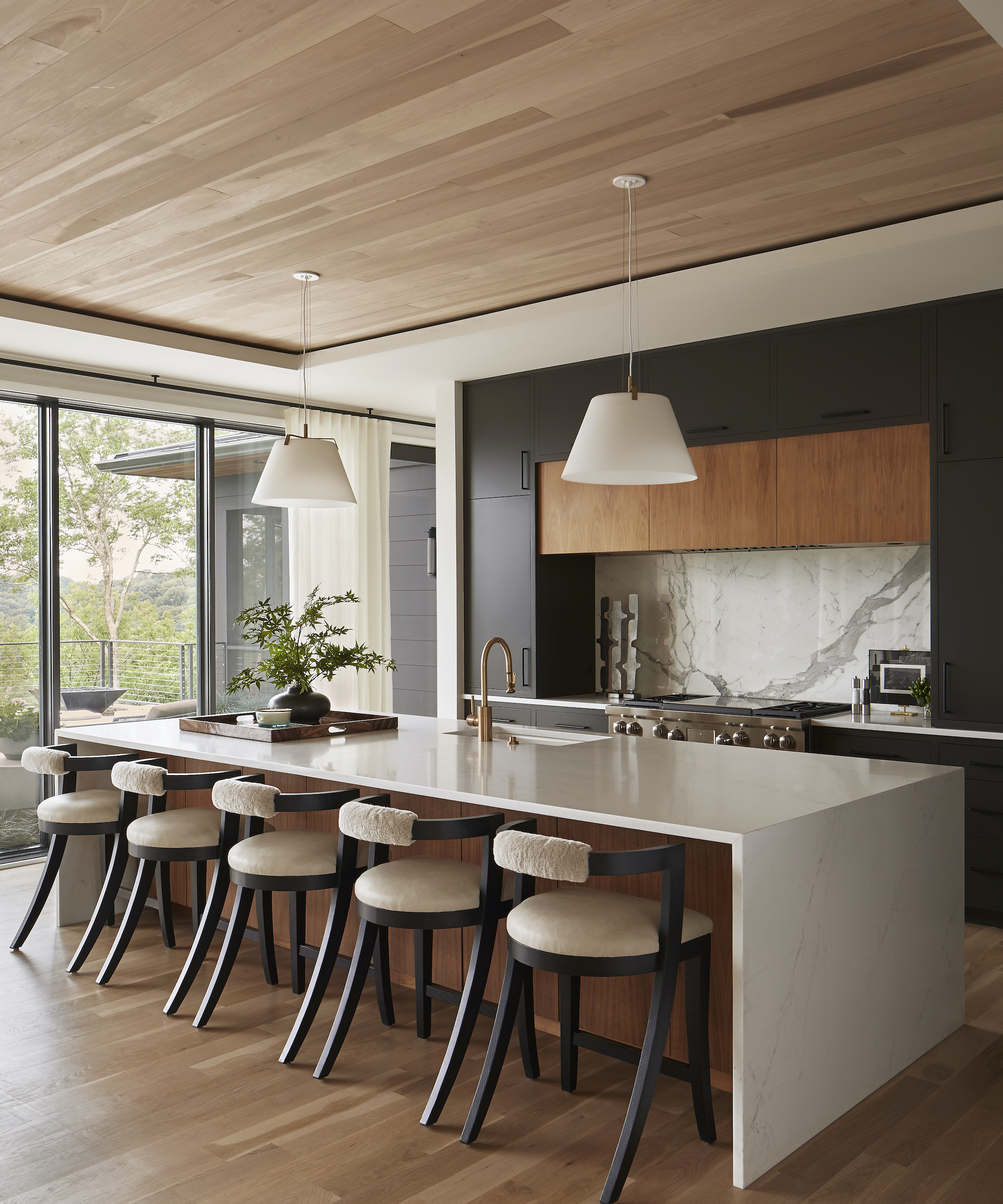 kitchen island with quartz tops and five bar stools and wood ceiling and floors