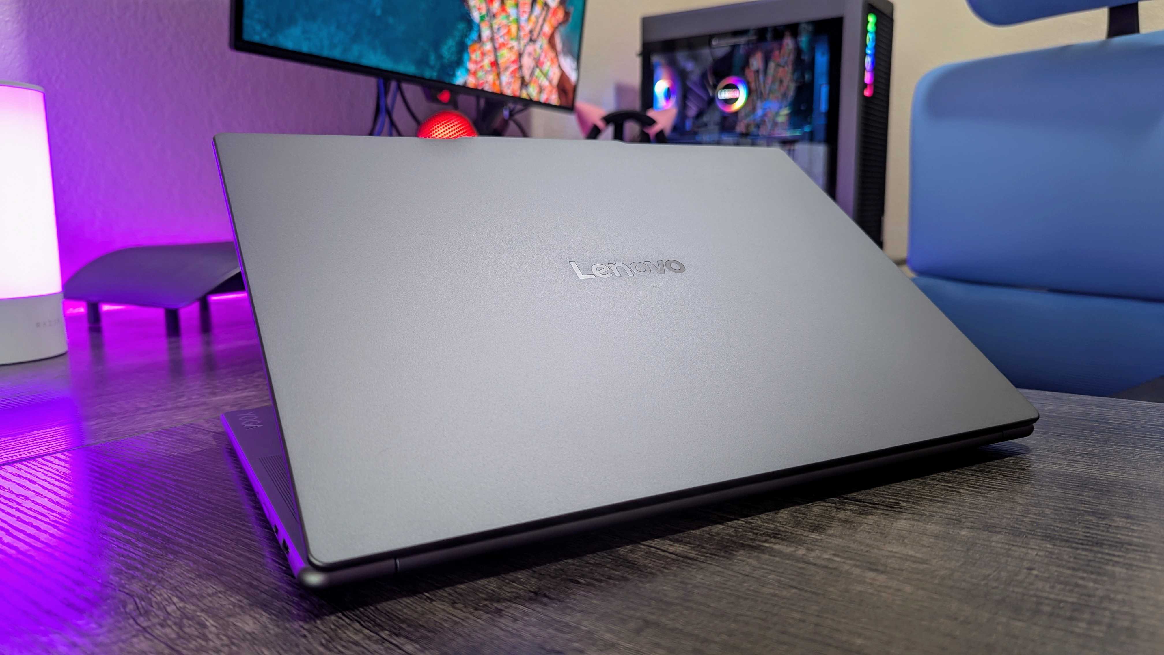 The Lenovo Yoga Slim 7i (Gen 9) Aura Edition on a desk with its logo facing forward and up.