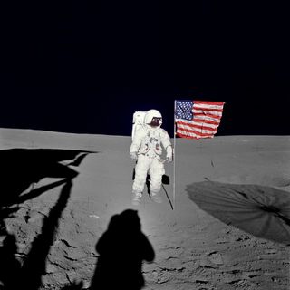 Ed Mitchell stands with the U.S. flag that he and Alan Shepard planted on the moon.