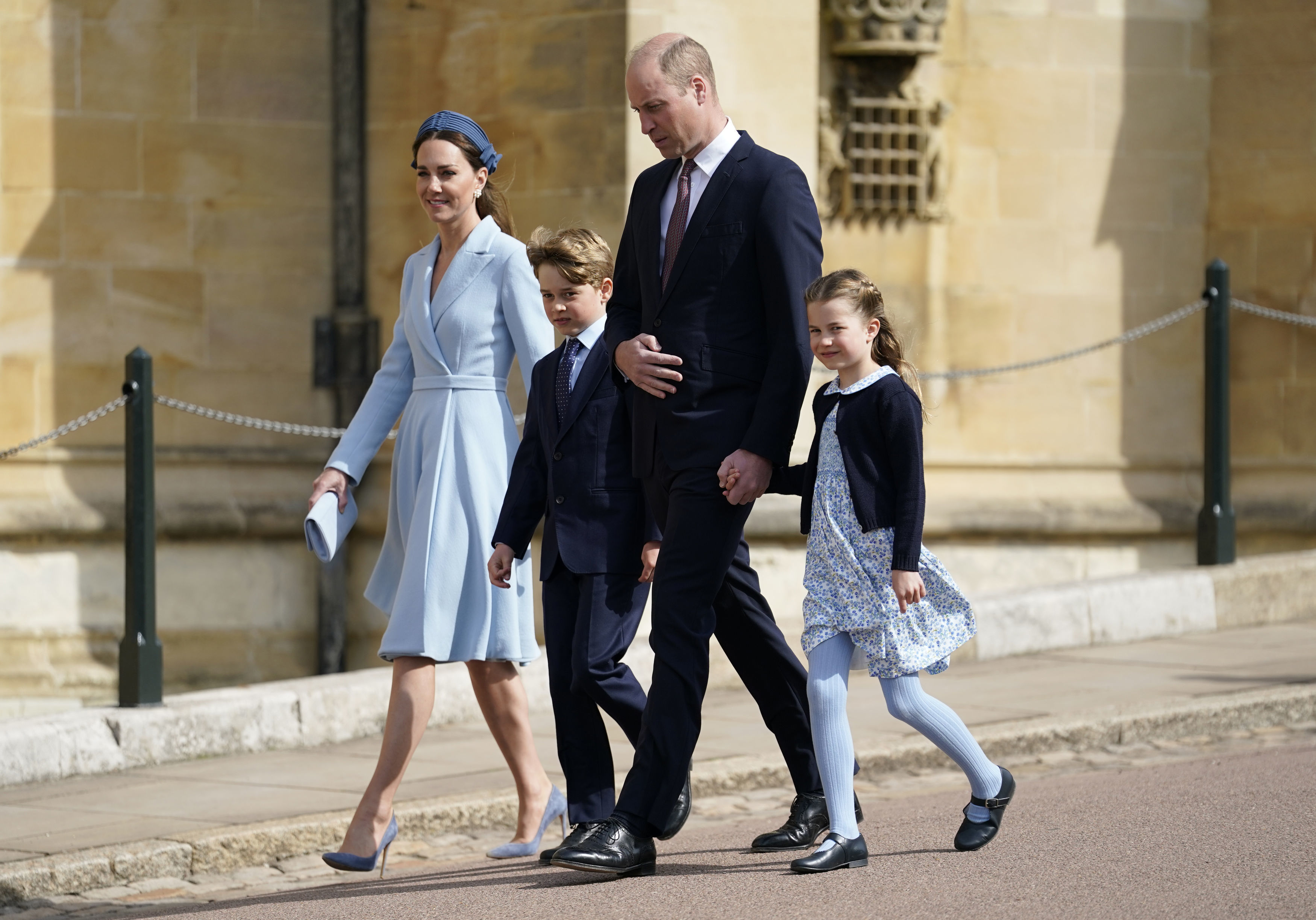 Princess Kate in a blue coat dress walking next to Prince George, Prince William and Princess Charlotte on Easter