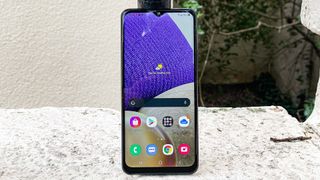 En Samsung Galaxy A32 står oprejst på en hvid overflade