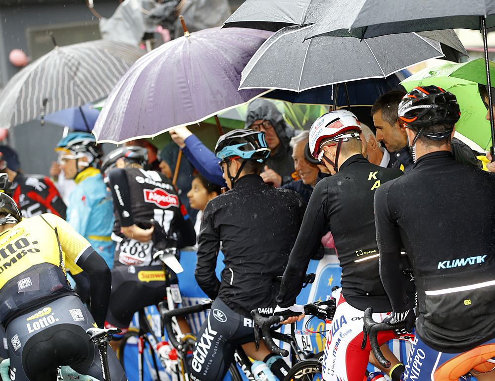Riders wait to start stage 8 of the Giro d'Italia in the rain