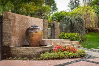 vase style garden fountain near garden steps