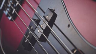 Close-up of bass guitar strings and pickups