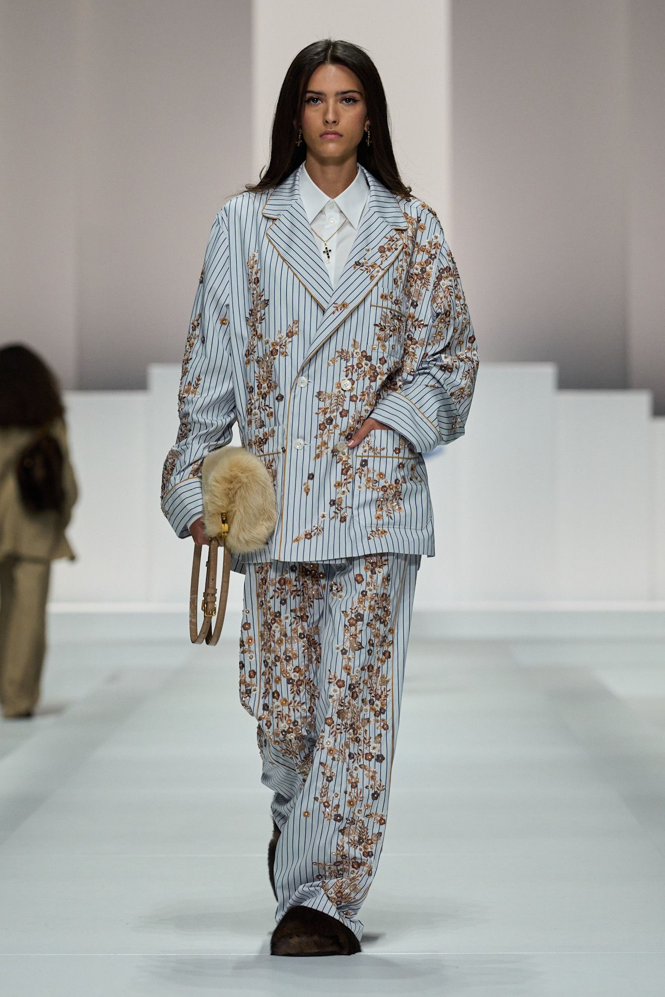 A model on dolce & Gabbana runway wears a pajama-inspired outfit with flroals.