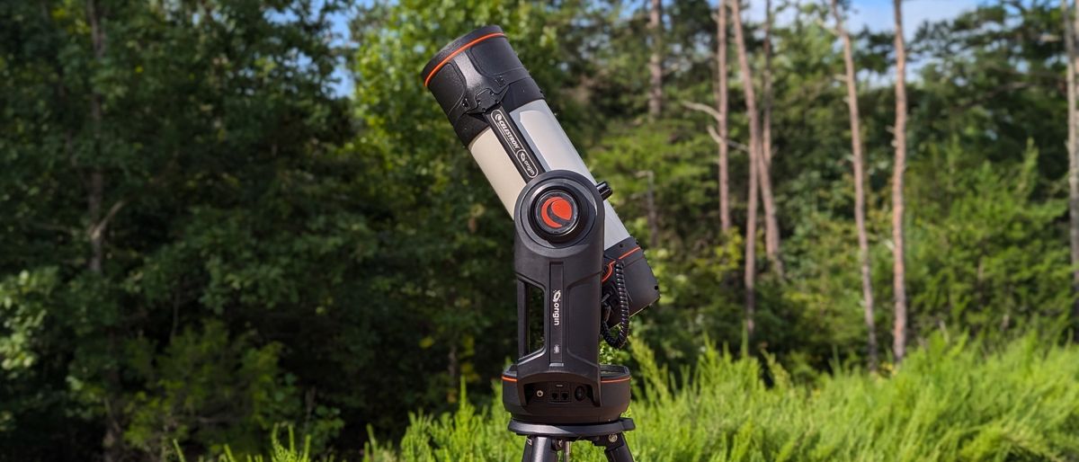 a black-and-white telescope standing in front of trees