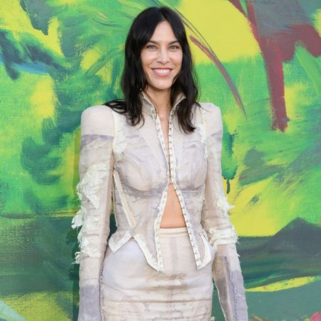 Alexa Chung poses for a photo at the Serpentine Summer party wearing a Dilara Findikoglu two-piece and PVC mule heels.