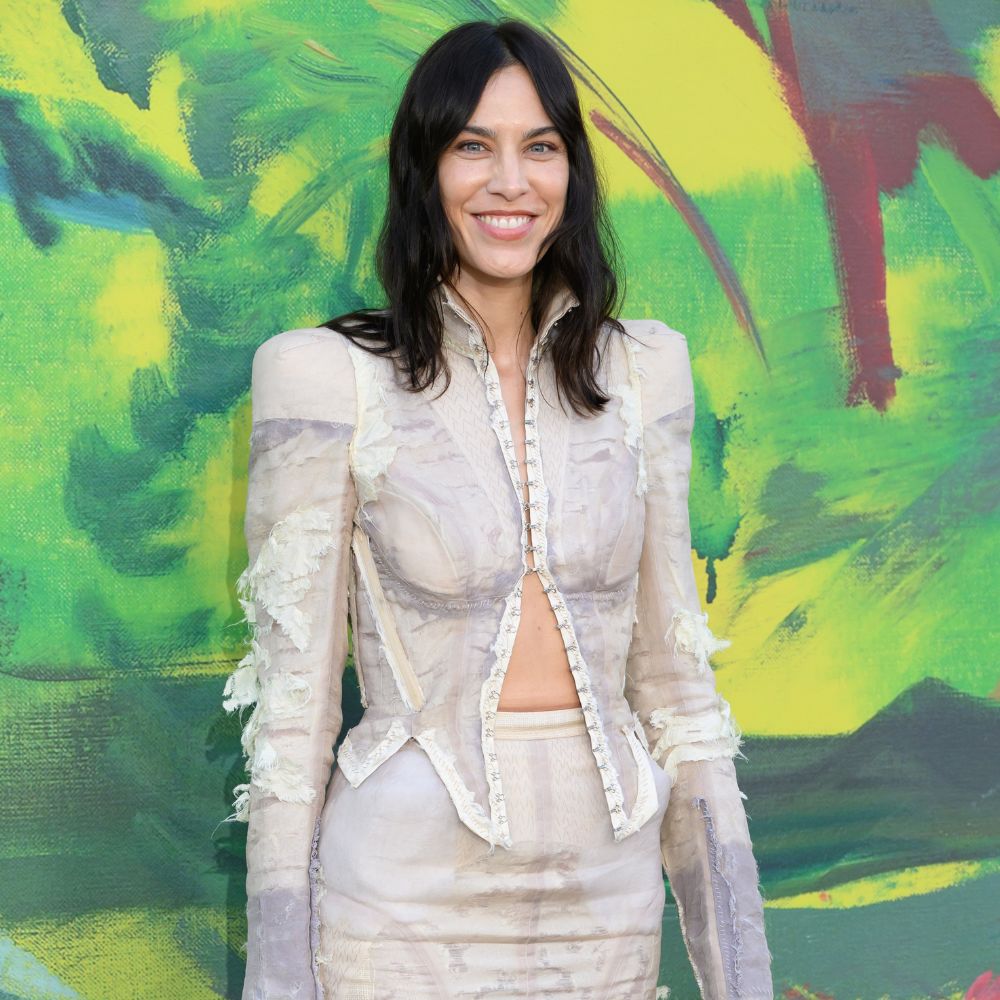 Alexa Chung poses for a photo at the Serpentine Summer party wearing a Dilara Findikoglu two-piece and PVC mule heels.