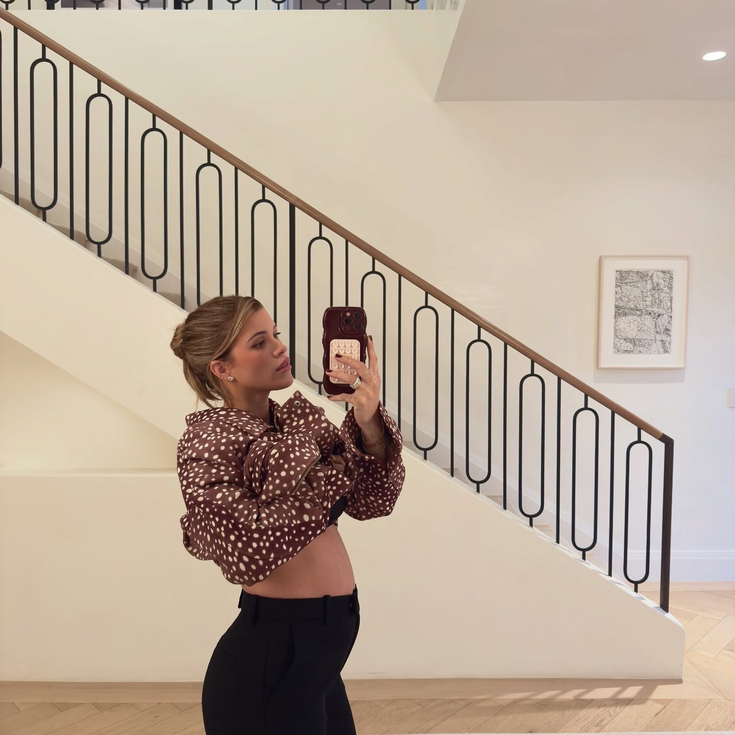 Sofia Richie Grainge announcing her second pregnancy in a SRG cow-print jacket and black pants.