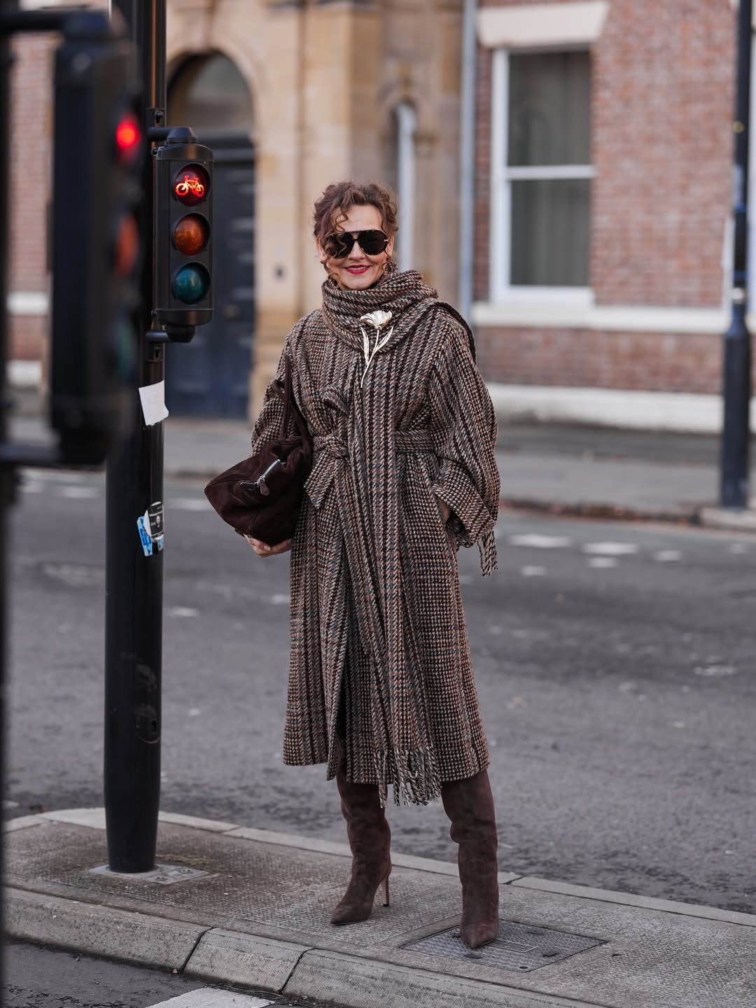 renia jaz wears a brown checked coat and brown suede boots