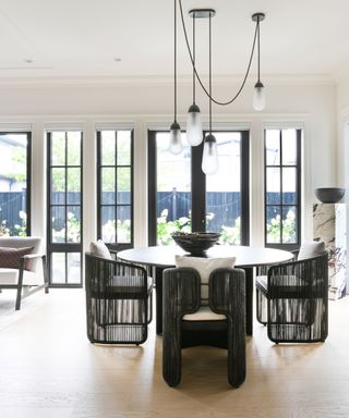 dining room with black chairs and windows all round