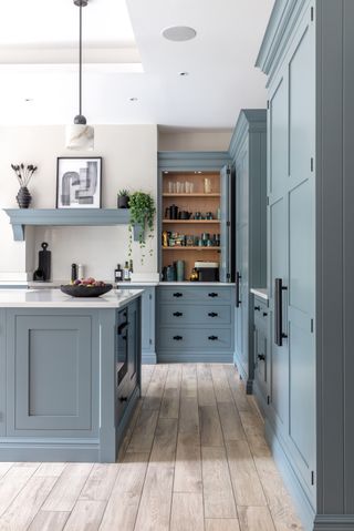 a blue grey shaker kitchen in a home with a skylight