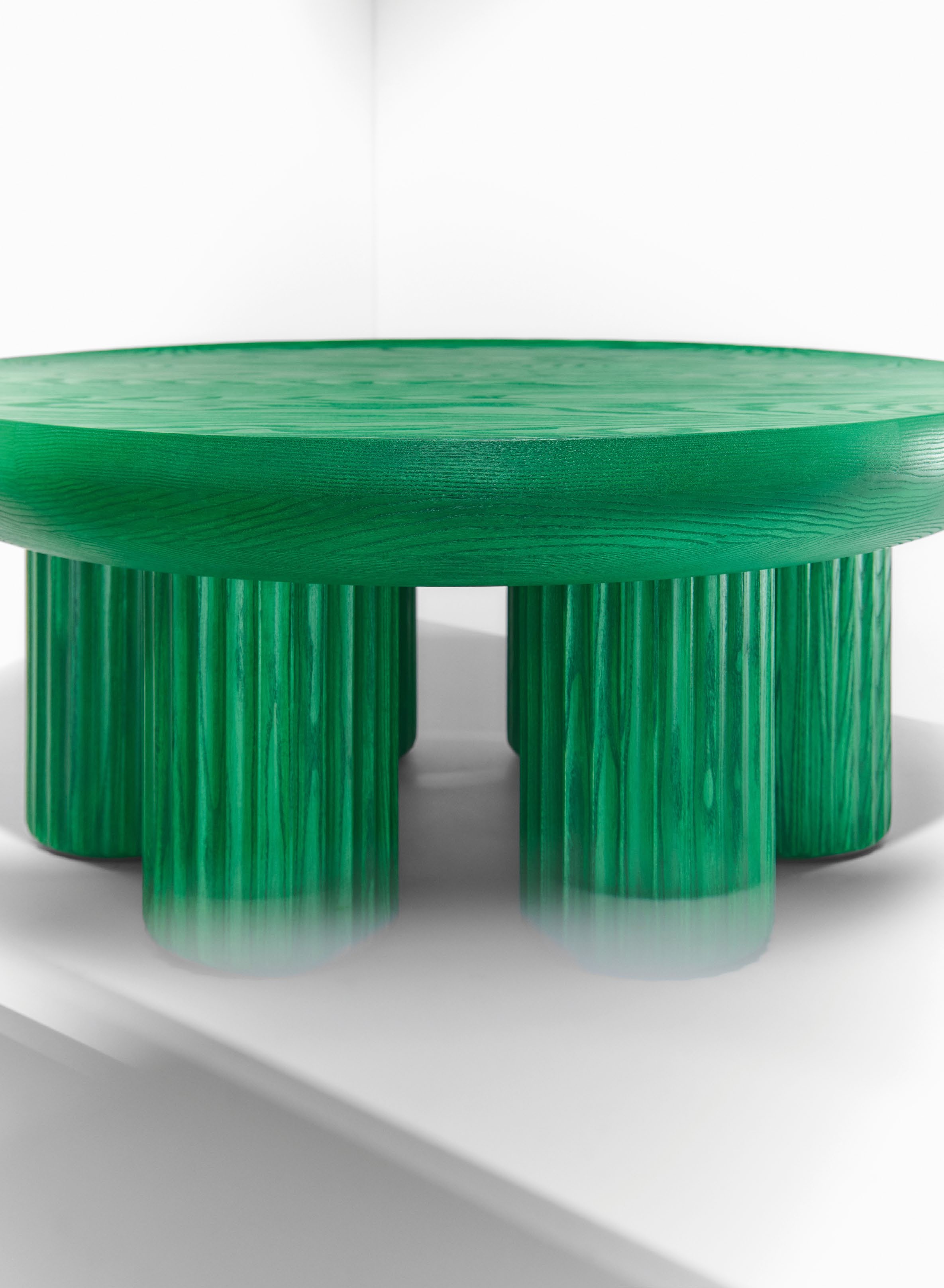 A handcrafted green table by Jiri Krejcirik, made from ash using traditional Czech woodworking techniques, featuring a round top and cylindrical legs.