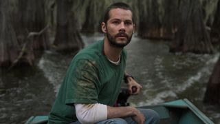 Dylan O'Brien drives a boat along a lake in Caddo Lake