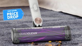 The cleaning head of the Shark Cordless Detect Pro on a dirty carpet with a deal badge for price drop