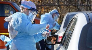 A nurse administers COVID-19 swab tests at a testing site in Brentwood, New York, on Nov. 18, 2020.