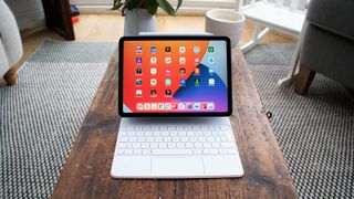 En iPad Air från 2022 står på ett vardagsrumsbord med ett tangentbord.