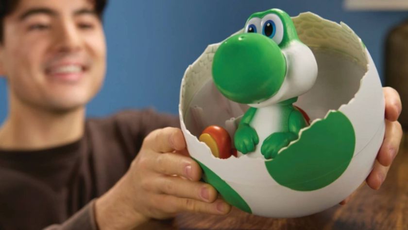 Official Smyths Toys product image showing someone holding up the Hatchin' Yoshi toy.