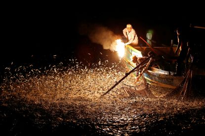 Fishermen use a fire to attract fish on a traditional “sulfuric fire fishing" boat in New Taipei City, Taiwan.