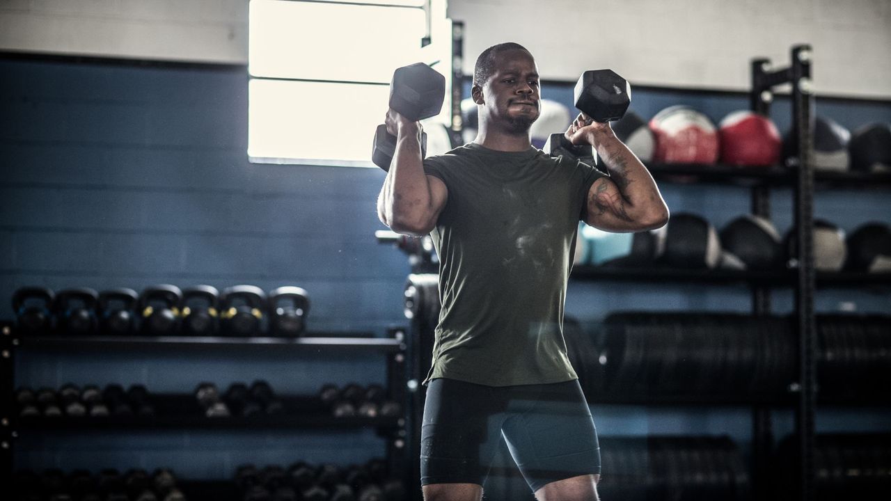 Man performing dumbbell shoulder press