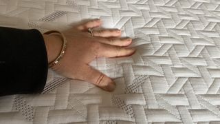 Tester's hand on the cooling cover of the Nectar Classic Memory Foam Mattress