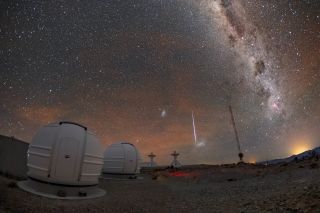 A "shooting star" streaks through the night sky near the Large and Small Magellanic Clouds, two of Earth's galactic neighbors, in this photo from the La Silla Observatory in Chile. In the foreground of the image are two of the three new ExTrA (Exoplanets in Transits and their Atmospheres) telescopes at the observatory.