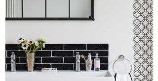 monochrome bathroom with black grid mirror above sink to show how cleaning iwth vinegar can get rid of marks and splashes on a mirror