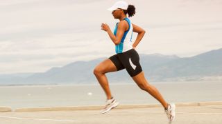 Woman running wearing a running cap