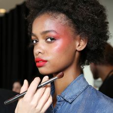 a model with red blusher make-up backstage at paris fashion week during the kenzo show - best red blusher