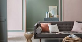 sage green living room with skirting boards painted in a warm off-whiite