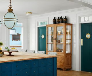 kitchen with white walls blue island and antique cabinet