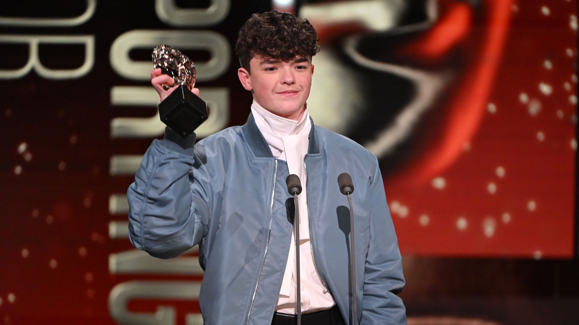 an image of Owen Cooper accepting the Supporting Actor Award for 'Adolescence' onstage during the 2026 BAFTA Television Awards