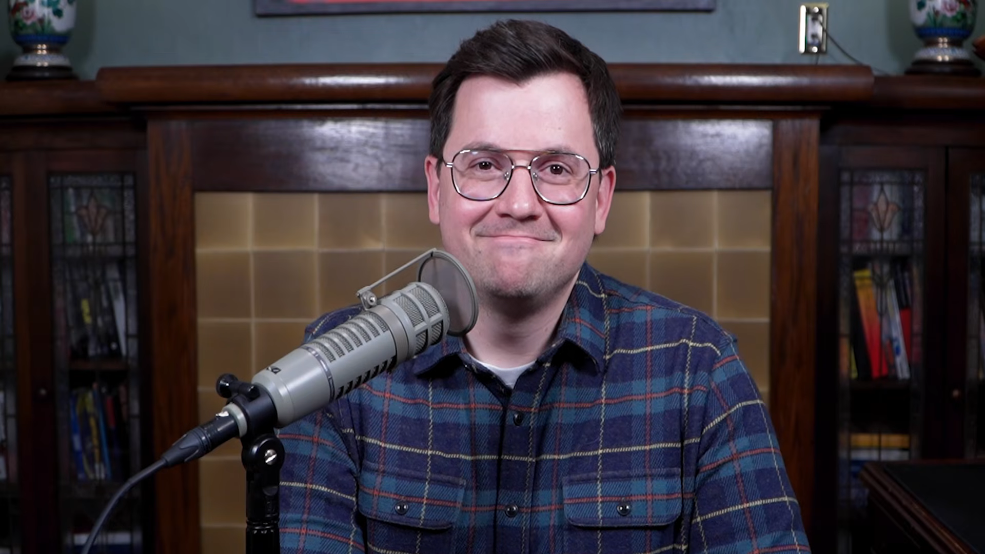 Norman Caruso, the Gaming Historian, smiles at the camera with a microphone in front of him.