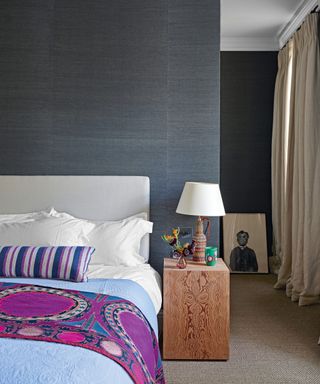 bedroom with dark gray walls and colorful bed throw