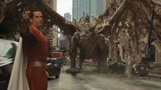 Shazam points at something off-screen in front of a dragon in Shazam! Fury of the Gods