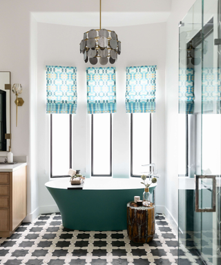 Blue geometric blinds in art deco style bathroom with teal tub, black and white star geometric square floor tile