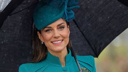 Catherine, Princess of Wales shelters from the rain beneath an umbrella during a visit to the 1st Battalion Irish Guards for their St Patrick's Day Parade 2023