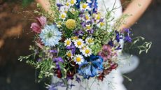 Bride holds bouquet of wildflowers at her wedding