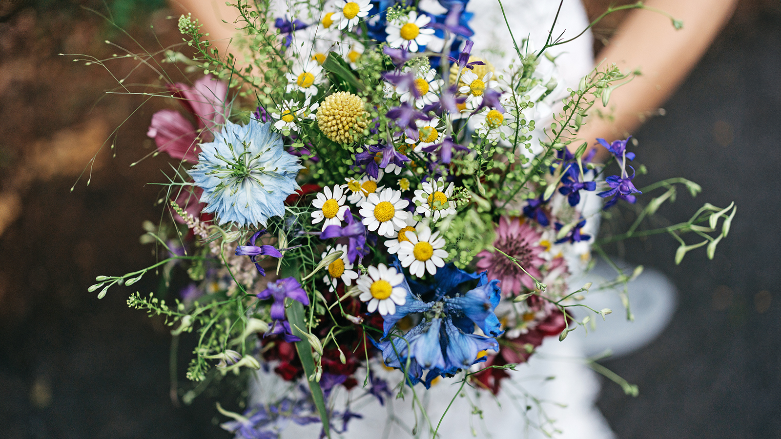 Bride holds bouquet of wildflowers at her wedding