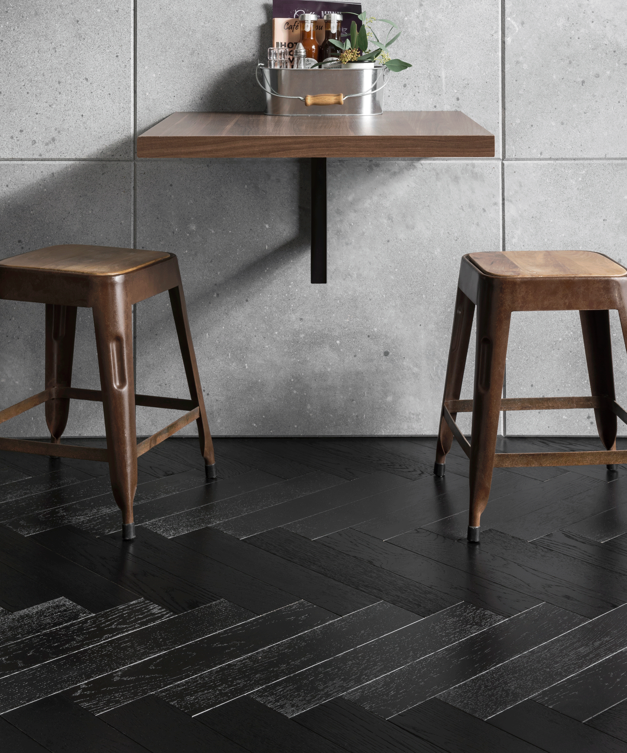 Kitchen stools against an island with black herringbone flooring
