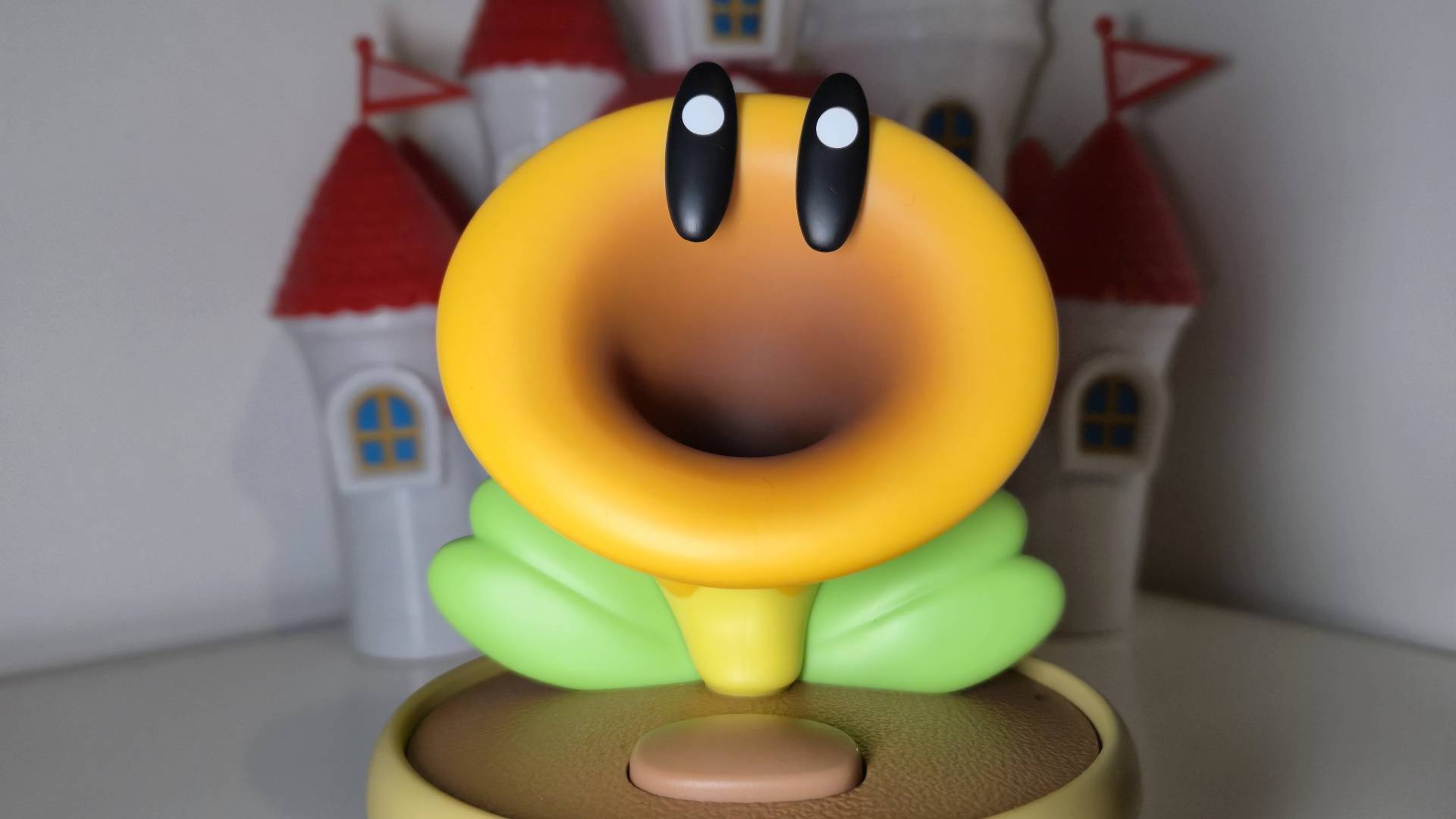 Close up photo of the Talking Flower toy sitting in front of a Peach Castle playset.