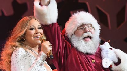 Mariah Carey performing on stage with Santa Claus